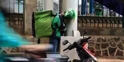Bikin Warganet Haru, Driver Ojol Ini Ketiduran Sambil Berdiri Saat Berteduh
