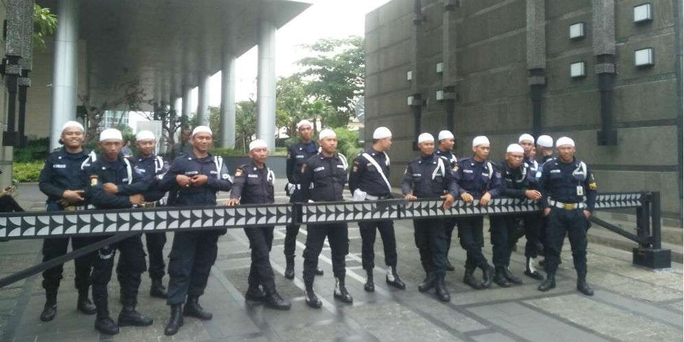Petugas yang berjaga mengenakan kopiah putih