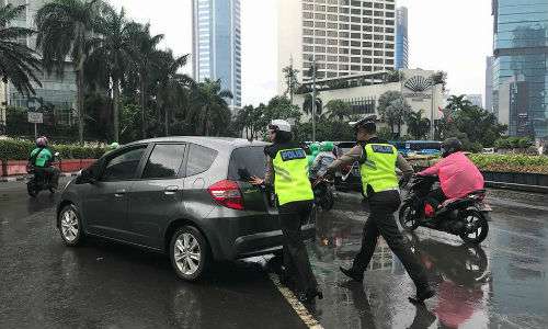 Polisi membantu mobil yang mogok di Bundaran HI