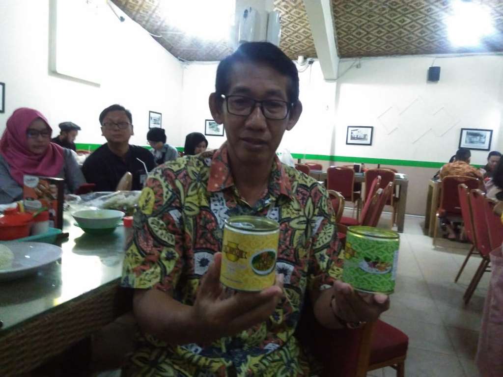 Apud memamerkan produk makanan kalengnya.