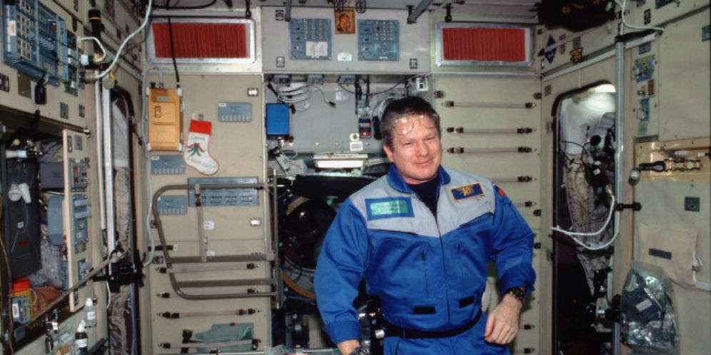 Seorang astronot mengenakan baju kerja berwarna biru