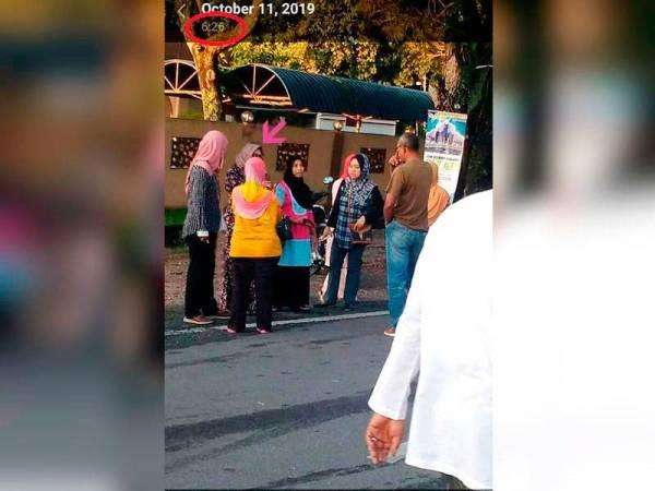 Faizah (arah panah pink) terlihat dalam foto yang secara misterius terekam satu jam sebelum kecelakaan.