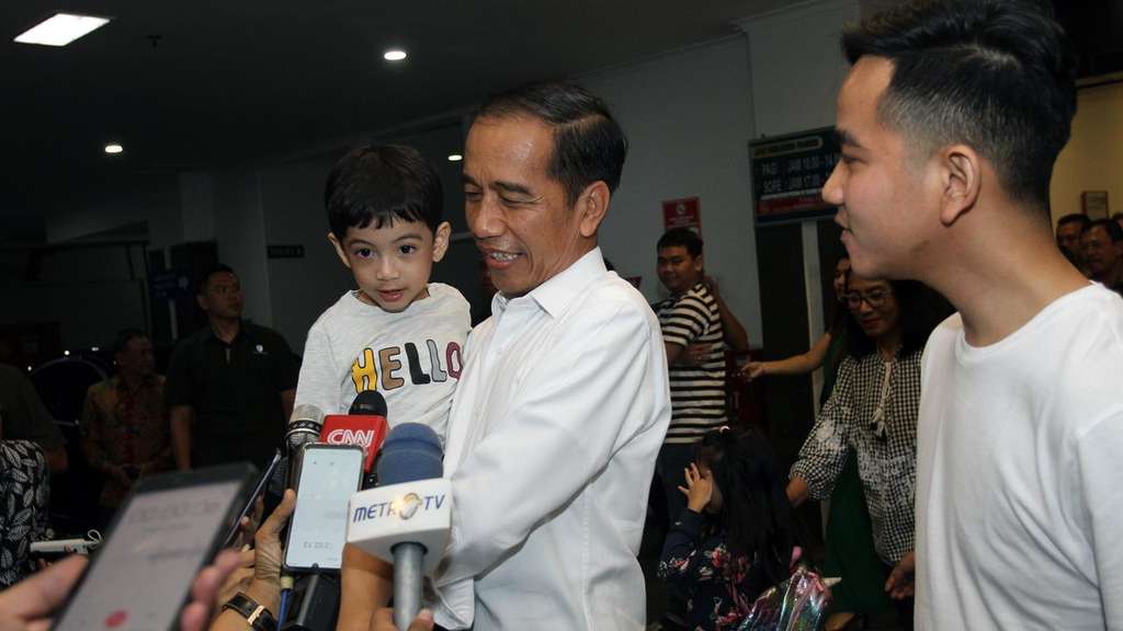 Jan Ethes Srinarendra yang digendong kakeknya Presiden Jokowi saat melayani pertanyaan media di RS PKU Muhammadiyah Solo, Jumat malam (15/11).(Liputan6.com/Fajar Abrori)
