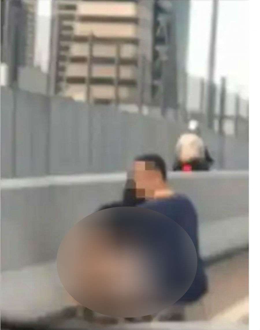 Aksi perempuan buang air besar di pinggir jalan tol(Foto: Oriental Daily)