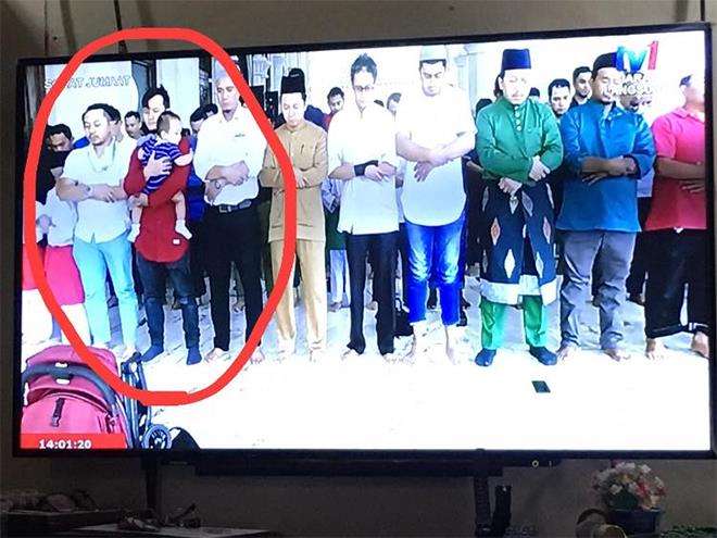 Pria ini viral. Sholat Jumat sambil gendong anak.