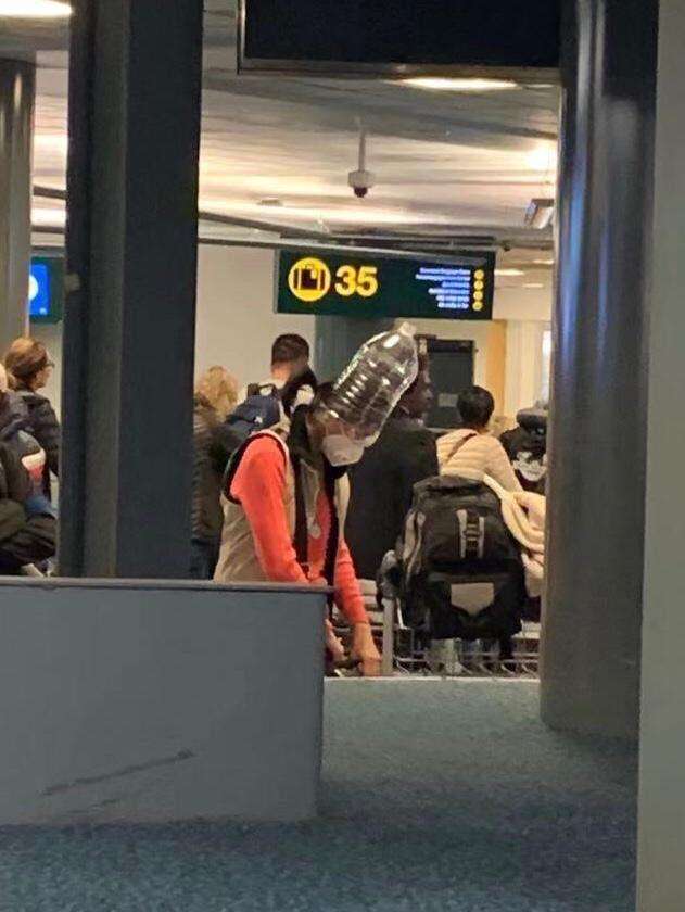 Memakai galon air agar tak tertular virus corona baru.