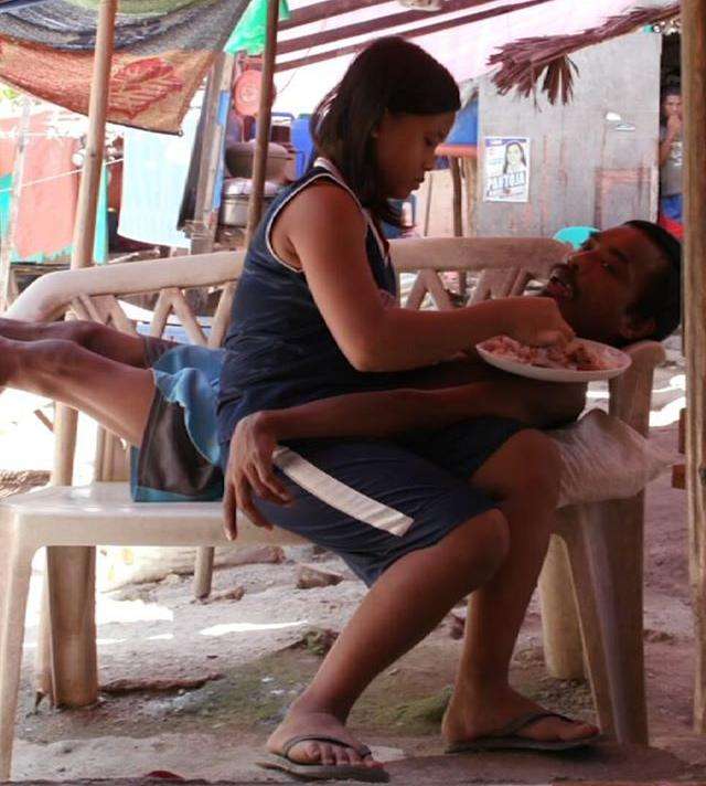 Marie menyuap ayahnya yang lumpuh dengan telaten.
