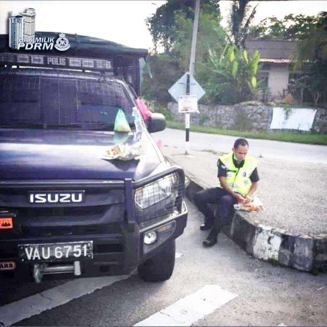 Polisi jaga lockdown di bawah terik matahari.