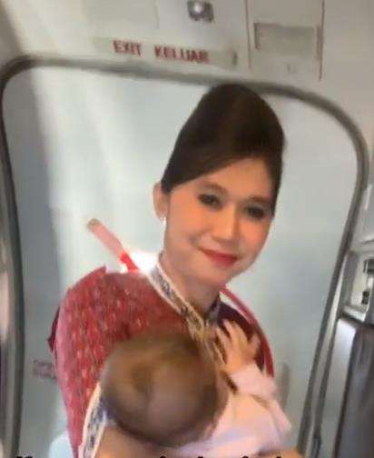 Pramugari gendong bayi saat bertugas.