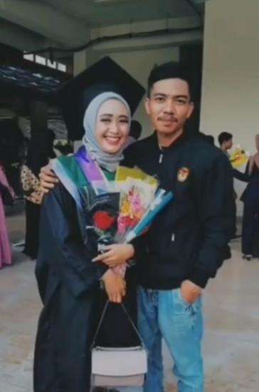 Sang suami menemani istri di acara wisuda.