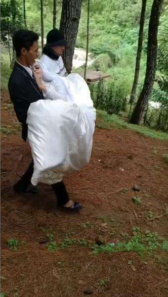 Menuruni bukit sambil menggendong pengantin wanita.