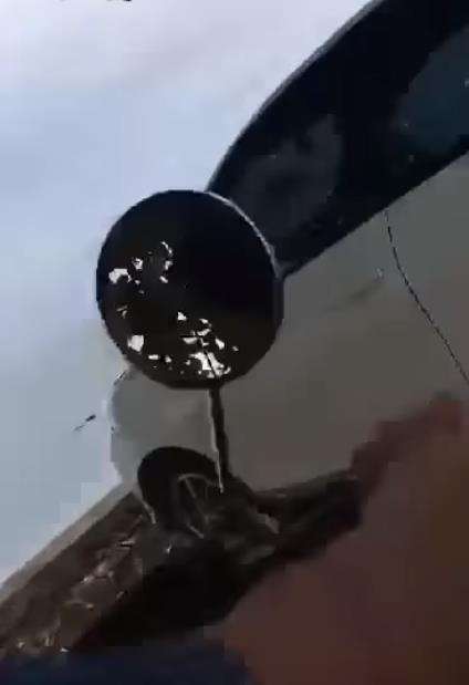 Mobil putih diparkir di pinggir pantai.
