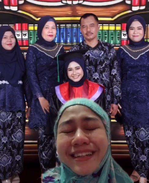 Sekarang foto wisudanya ada ibunya yang berdiri di sebelah kiri ayahnya.