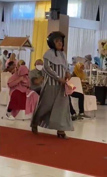 Rupanya dia lupa melepas helm setelah parkir di depan gedung.