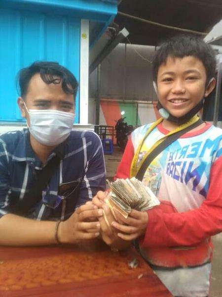 Gilang memegang sebundel uang hasil dari parkir hari itu.