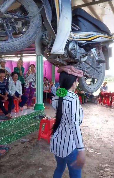 Wanita terkuat, angkat motor pakai kepala.