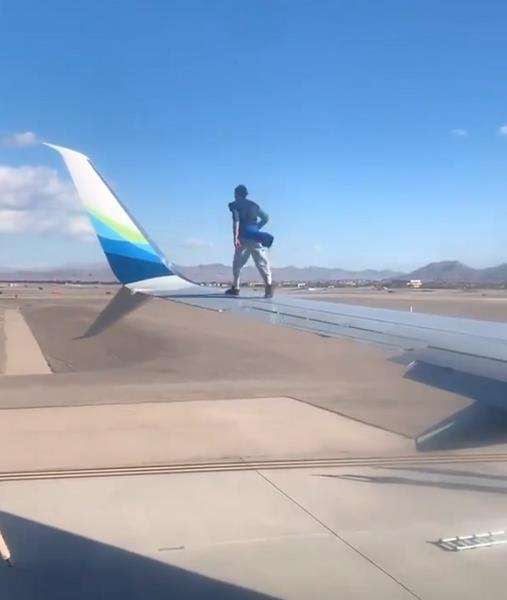 Bukannya menyerah, pria ini malah berusaha memanjat winglet pesawat.