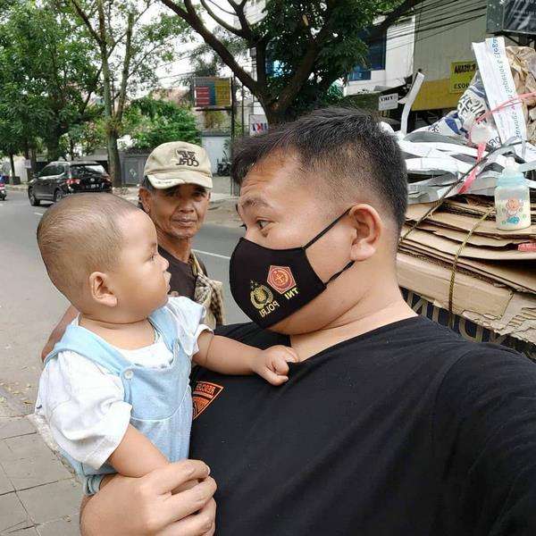 Joshua ikut menggendong dan mengajak bercanda anak Pak Dede.