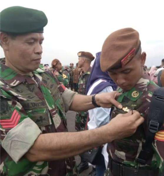Pak Tauchid merapikan baju putranya, Bagas.