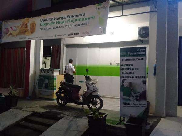 Satpam sholat di emperan kantornya yang tutup.
