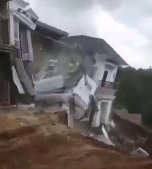 Rumah itu roboh saat tanah di bawahnya longsor.