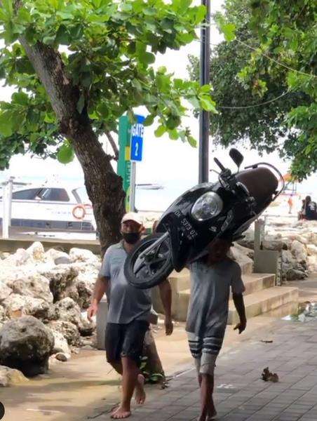 Aksi pria gendong motor seperti angkat galon air.
