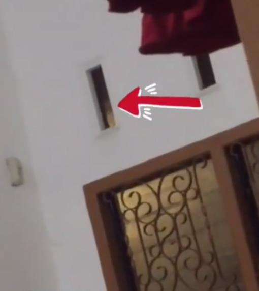 Tampak ada orang sedang mengintip bagian dalam rumah kos lewat lubang angin.