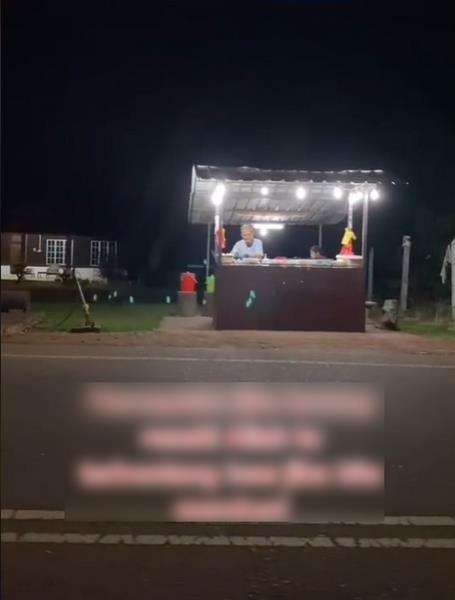 Lapak kakek ini berada di depan kuburan yang terbentang sepanjang jalan.