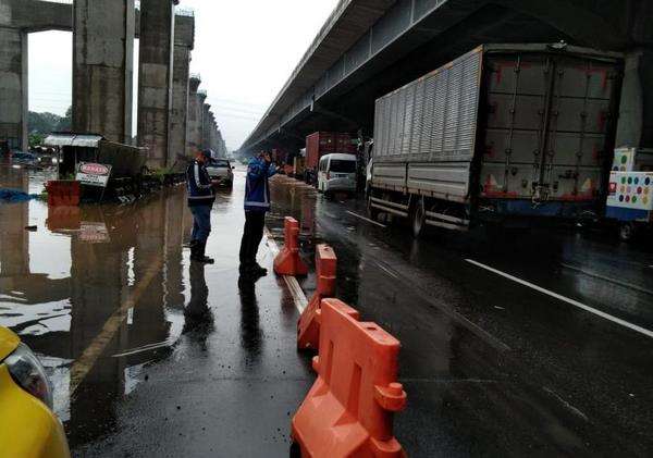 Petugas mengalihkan arus akibat banjir di ruas jalan tol Jasa Marga.