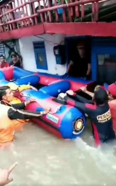 Evakuasi jenazah di tengah banjir berarus deras.