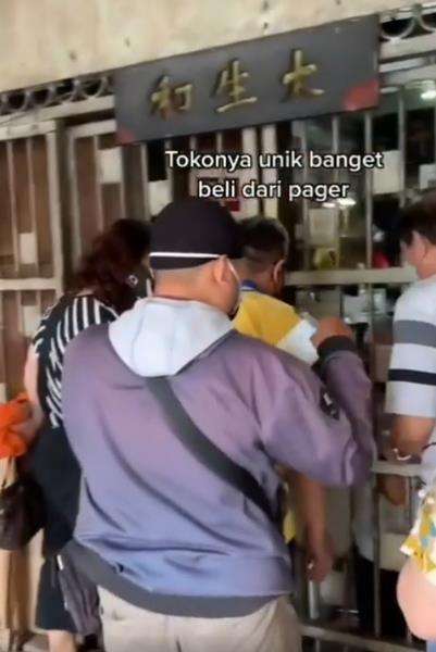 Toko obatnya dibatasi oleh pagar besi.