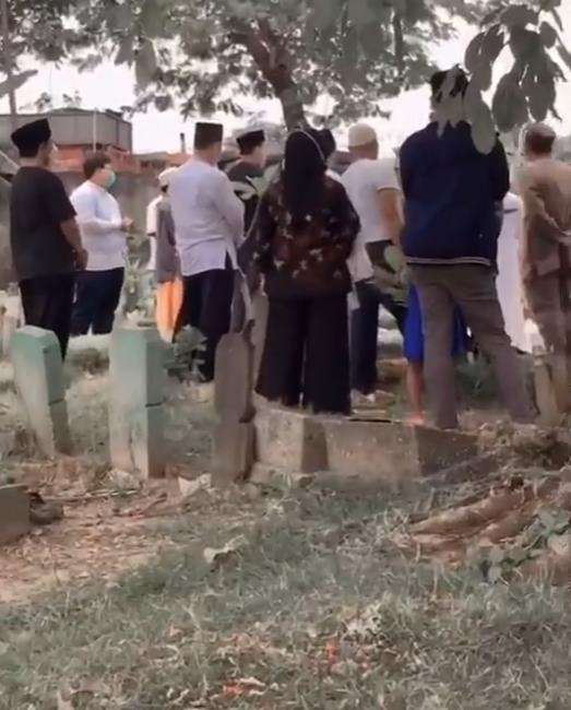 Tampak para peziarah menghadiri pemakaman kerabat perekam video.