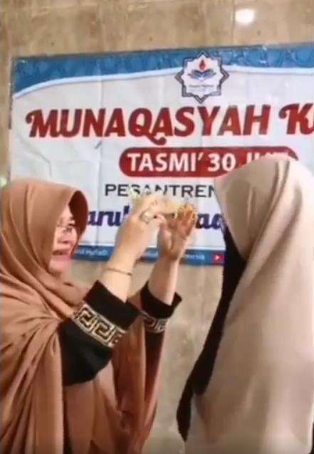 Ibu itu terus menangis saat memakaikan mahkota ke atas kepala putrinya.