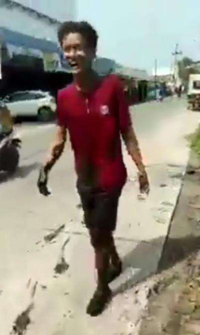 Seorang pemuda tertawa usai jatuh ke dalam selokan.