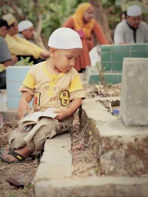 Adik kecil sedih menatap makam