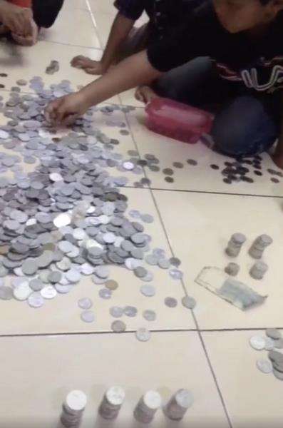 Uang receh dari celengan dituang ke atas lantai.