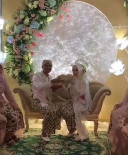 Kedua mempelai saling suap bakso goreng di pelaminan.