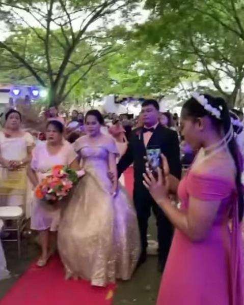Pengantin wanita berjalan menuju pelaminan.