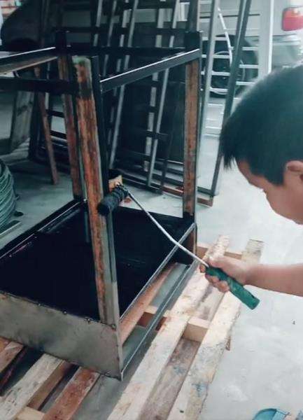 Dengan tekunnya dia mengecat meja.