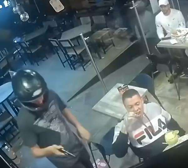 Lelaki ini tetap santai makan ayam goreng meski ditodong pistol.