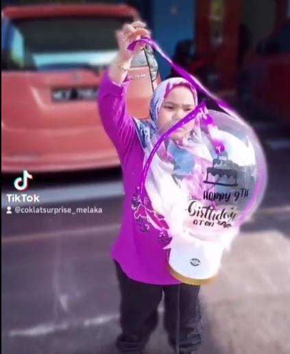 Berusaha melepas pita yang menghiasi balon.