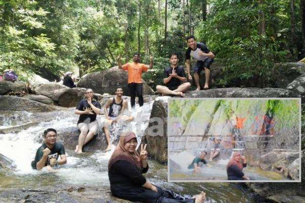Berwisata di air terjun di tengah hutan.