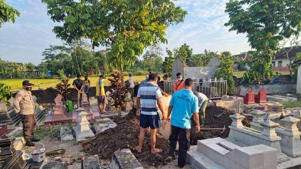 Suasana pembongkaran makam yang tali pocongnya belum dilepas.
