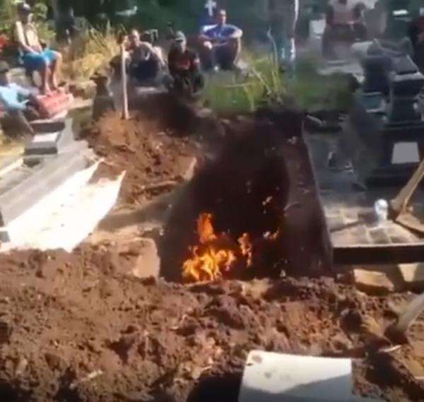 Penampakan liang lahat terbakar dengan api yang menyala-nyala.