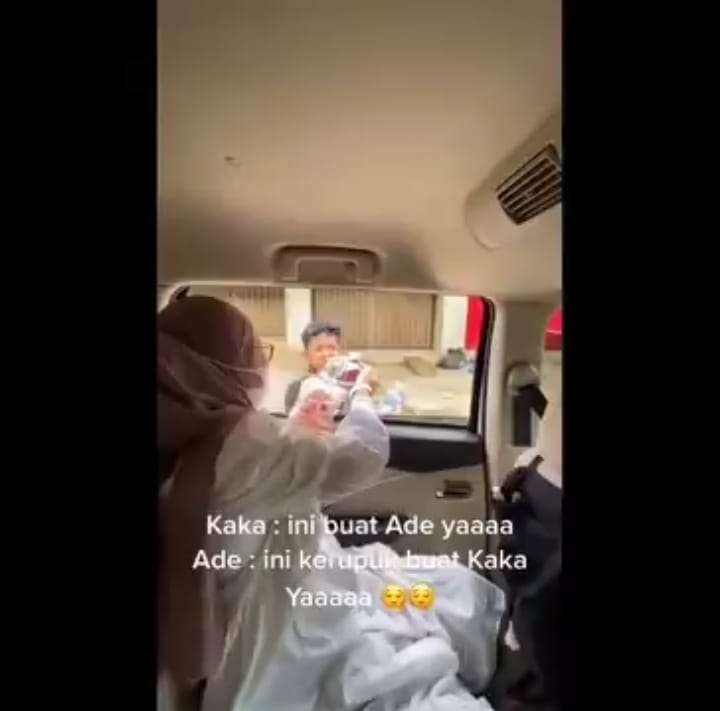 Wanita Memberikan Bendera dan Uang pada Anak Penjual Kerupuk
