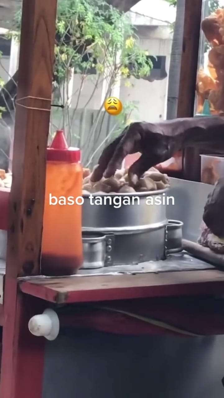 Pedagang Bakso Gerobag Mengambil Bakso dengan Tangannya