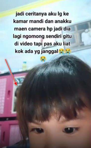 Terlihat sosok di belakang kepala bocah perempuan.