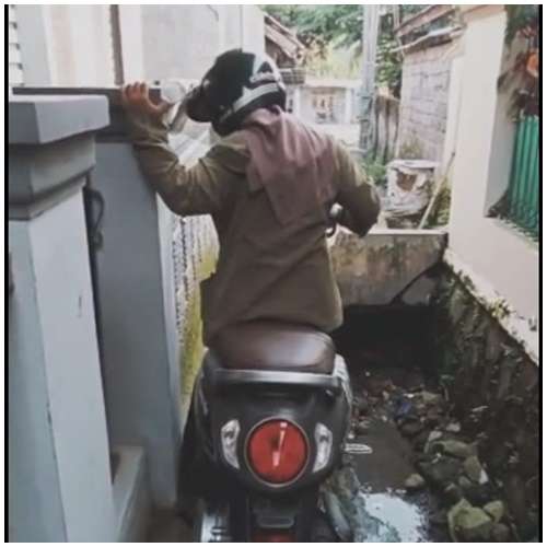 Wanita Berjuang Mengeluarkan Motor dari Area Sempit