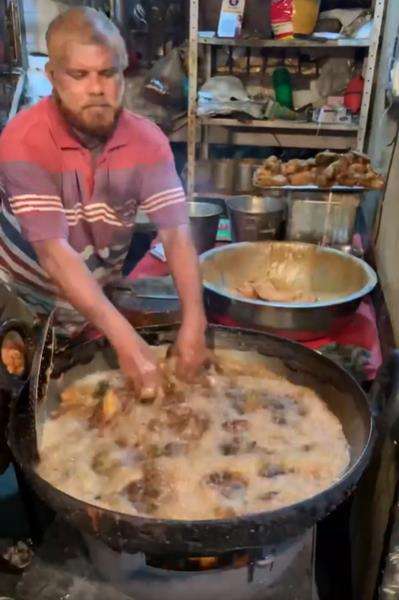 Aksi penjual fried chicken kaki lima goreng ayam pakai tangan kosong.