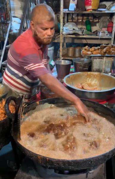 Aksi penjual fried chicken kaki lima goreng ayam pakai tangan kosong.